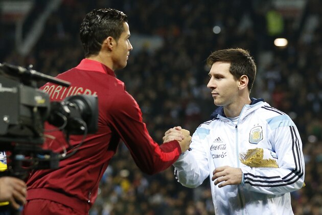 Lionel Messi of Argentina, right, greets Cristiano Ronaldo of Portugal before their International Friendly soccer match at Old Trafford Stadium, Manchester, England, Tuesday Nov. 18, 2014. (AP Photo/Jon Super)