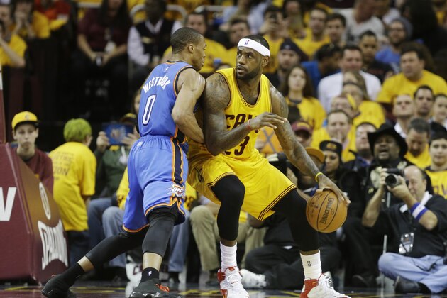 Cleveland Cavaliers' LeBron James backs in against Oklahoma City Thunder's Russell Westbrook (0) in an NBA basketball game Sunday, Jan. 25, 2015, in Cleveland. (AP Photo/Mark Duncan)