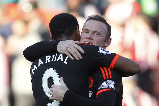 Manchester United's English striker Wayne Rooney embraces Manchester United's French striker Anthony Martial (L) after the English Premier League football match between Southampton and Manchester United at St Mary's Stadium in Southampton, southern England on September 20, 2015. Manchester United won the game 3-2. AFP PHOTO / IAN KINGTON

RESTRICTED TO EDITORIAL USE. No use with unauthorized audio, video, data, fixture lists, club/league logos or 'live' services. Online in-match use limited to 75 images, no video emulation. No use in betting, games or single club/league/player publications.        (Photo credit should read IAN KINGTON/AFP/Getty Images)