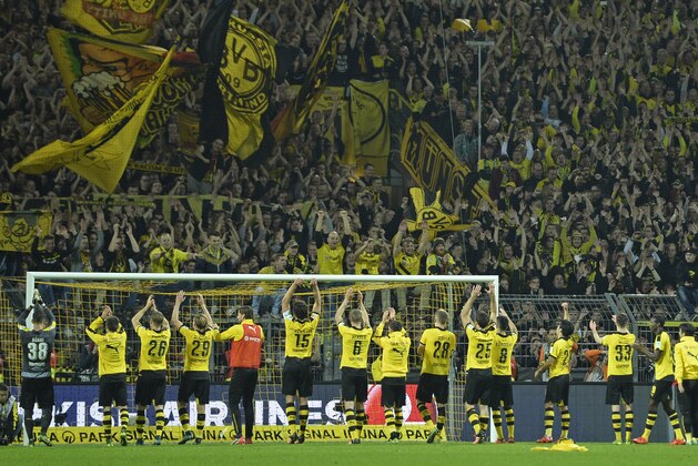 Dortmund's team celebrates with fans after the German Bundesliga soccer match between Borussia Dortmund and FC Schalke 04 in Dortmund, Germany, Sunday, Nov. 8, 2015. Dortmund defeated Schalke  by  3-2. (AP Photo/Martin Meissner)