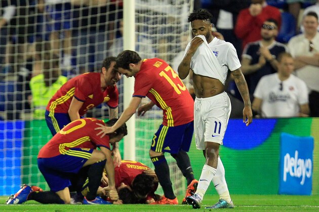 England’s Raheem Sterling, right, reacts as Spain palyers celebrate after scoring the opening goal during an international friendly soccer match between Spain and England at the Rico Perez Stadium in Alicante, Spain, Friday, Nov. 13, 2015. (AP Photo/Alberto Saiz)