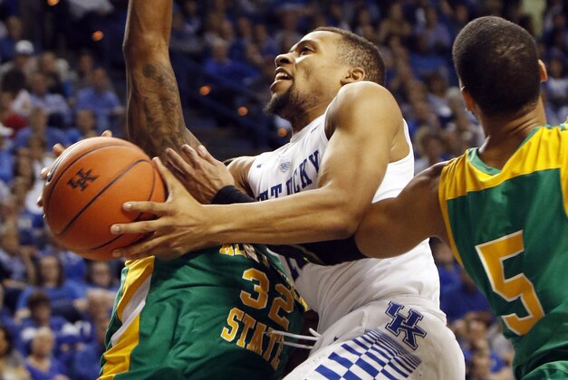 Kentucky's Isaiah Briscoe, center, is fouled by Kentucky State's Kevin Shaw (5) and defended by William Bryant (32) during the second half of an NCAA college basketball game Friday, Nov. 6, 2015, in Lexington, Ky. (AP Photo/James Crisp)