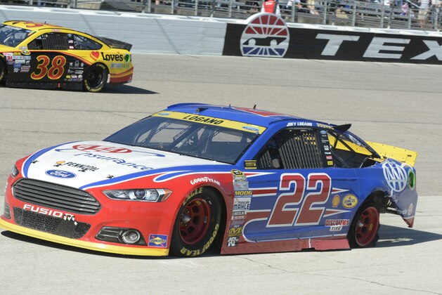Joey Logano (22) pulls onto pit row with a shredded back tire during the NASCAR Sprint Cup Series auto race at Texas Motor Speedway in Fort Worth, Texas, Sunday, Nov. 8, 2015. (AP Photo/Larry Papke)