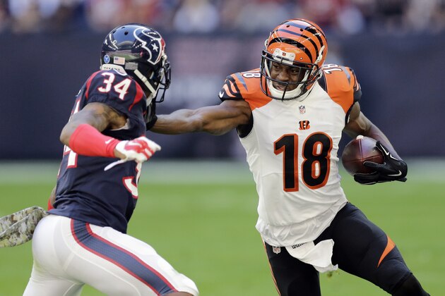 Cincinnati Bengals' A.J. Green (18) tries to avoid Houston Texans' A.J. Bouye (34) as he runs with the ball during the first quarter of an NFL football game, Sunday, Nov. 23, 2014, in Houston. (AP Photo/Patric Schneider)