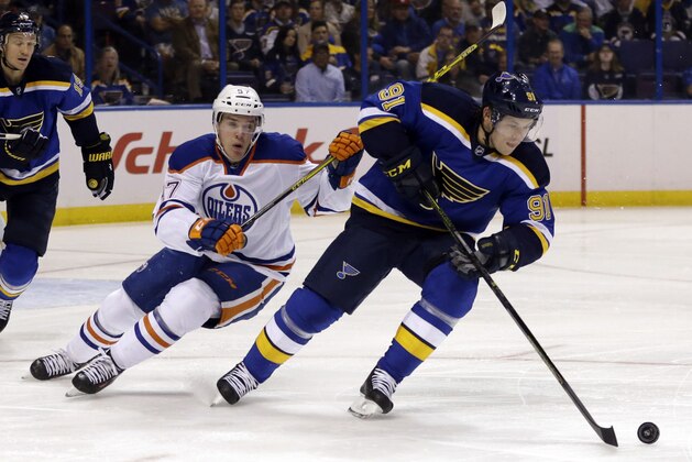 St. Louis Blues' Vladimir Tarasenko, of Russia, controls the puck as Edmonton Oilers' Connor McDavid, left, gives chase during the first period of an NHL hockey game Thursday, Oct. 8, 2015, in St. Louis. (AP Photo/Jeff Roberson)