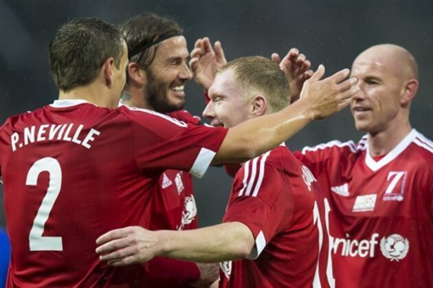 Great Britain and Ireland's Paul Scholes, center right, celebrates scoring with teammates during the Unicef Match for Children charity football match between a Great Britain and Ireland team and a Rest of the World team at Old Trafford Stadium, Manchester, England, Saturday, Nov. 14, 2015. (AP Photo/Jon Super)