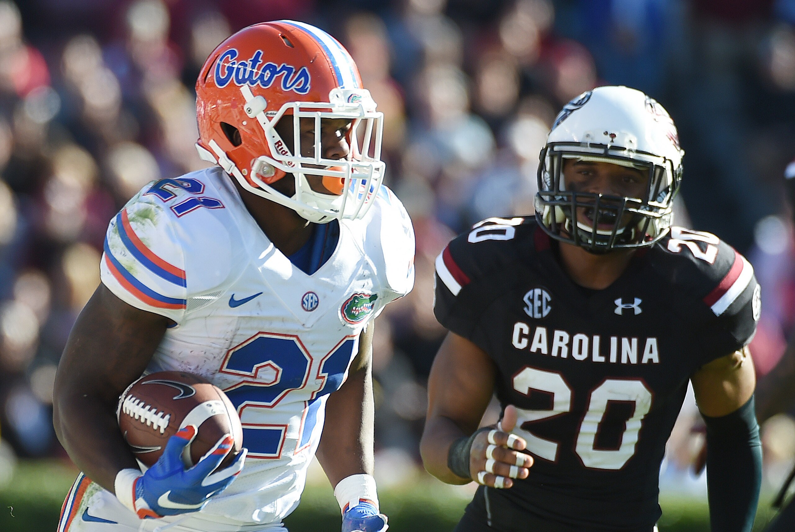 Florida running back Kelvin Taylor (21) runs for yardage as South Carolina safety T.J. Gurley (20) defends during the second half of an NCAA college football game, Saturday, Nov. 14, 2015, in Columbia, S.C. Florida won 24-14. (AP Photo/Rainier Ehrhardt)