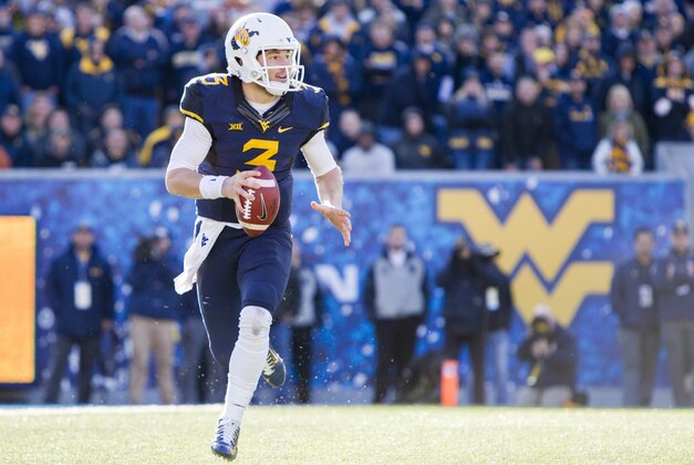 Nov 14, 2015; Morgantown, WV, USA; West Virginia Mountaineers quarterback Skyler Howard rolls out of the pocket during the fourth quarter against the Texas Longhorns at Milan Puskar Stadium. Mandatory Credit: Ben Queen-USA TODAY Sports