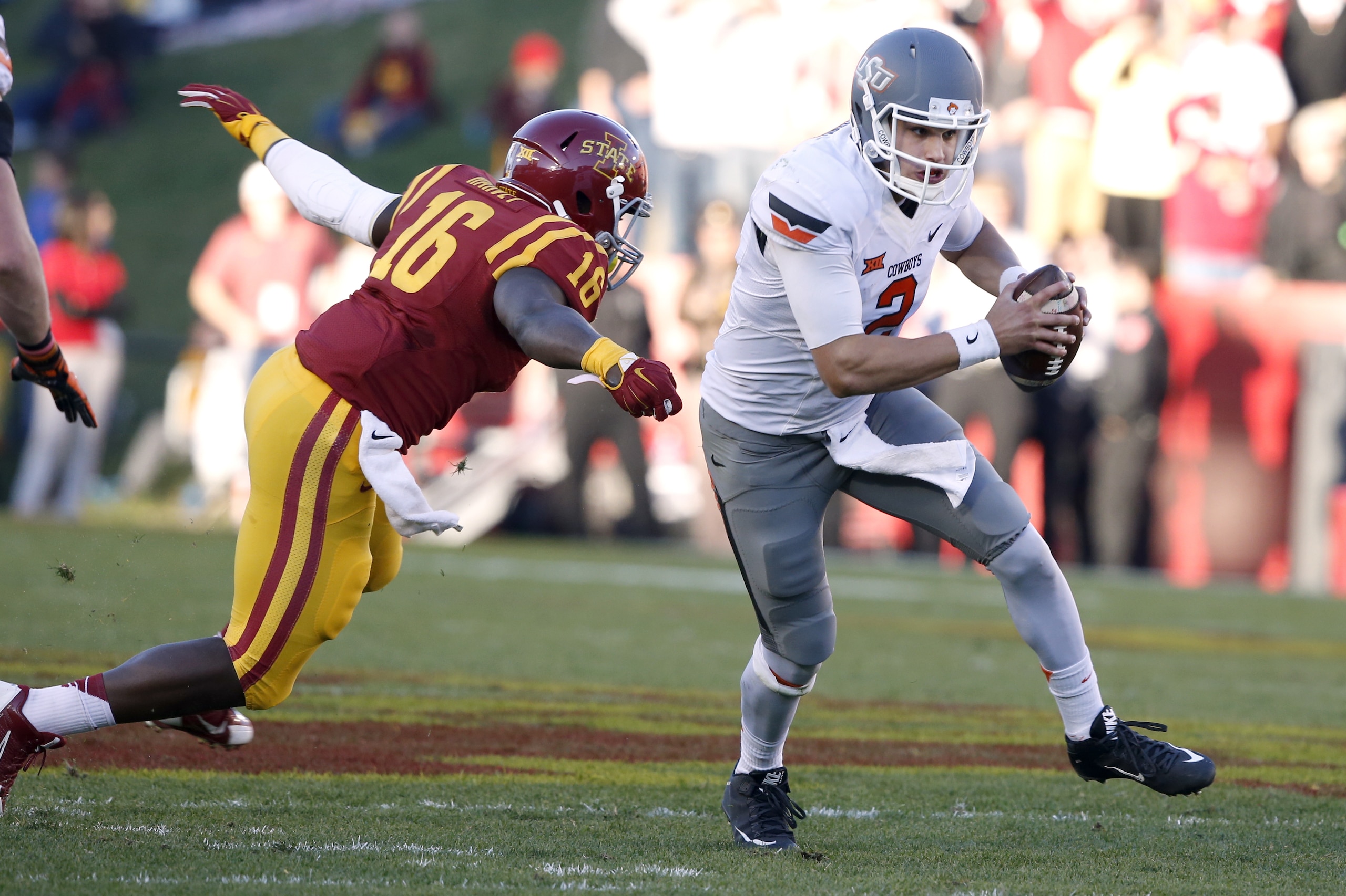 AMES, IA - NOVEMBER 14: Quarterback Mason Rudolph #2 of the Oklahoma State Cowboys breaks away from linebacker Willie Harvey #16 of the Iowa State Cyclones as he scrambles for yards in the first half of play at Jack Trice Stadium on November 14, 2015 in Ames, Iowa. (Photo by David Purdy/Getty Images)