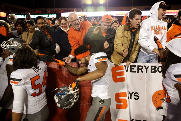 Oklahoma State fans celebrate with the Oklahoma State wide receiver Marcell Ateman after their 35-31 victory over Iowa State during an NCAA college football game, Saturday, Nov. 14, 2015, in Ames, Iowa. (AP Photo/Justin Hayworth)