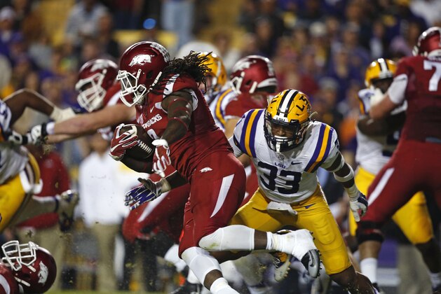 Arkansas running back Alex Collins (3) carries pastor LSU safety Jamal Adams (33) in the first half of an NCAA college football game in Baton Rouge, La., Saturday, Nov. 14, 2015. (AP Photo/Gerald Herbert)