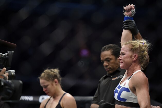 Holly Holm, right, celebrates after defeating Ronda Rousey, left, during their UFC 193 Bantamweight title fight in Melbourne, Australia, Sunday, Nov. 15, 2015. (AP Photo/Andy Brownbill)