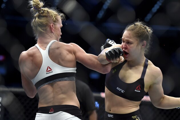 Holly Holm, left, and Ronda Rousey exchange their punches during their UFC 193 bantamweight title fight in Melbourne, Australia, Sunday, Nov. 15, 2015. Holm pulled off a stunning upset victory over Rousey in the fight, knocking out the women's bantamweight champion in the second round with a powerful kick to the head Sunday. (AP Photo/Andy Brownbill)