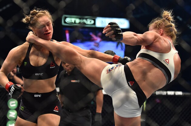 Holly Holm of the US (R) lands a kick to the neck to knock out compatriot Ronda Rousey and win the UFC title fight in Melbourne on November 15, 2015.   RESTRICTED TO EDITORIAL USE NO ADVERTISING USE NO PROMOTIONAL USE NO MERCHANDISING USE.  AFP PHOTO/Paul CROCK        (Photo credit should read PAUL CROCK/AFP/Getty Images)