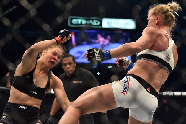 Ronda Rousey of the US (L) goes down after being knocked out by compatriot Holly Holm by a kick to the neck to end the UFC title fight in Melbourne on November 15, 2015.   RESTRICTED TO EDITORIAL USE NO ADVERTISING USE NO PROMOTIONAL USE NO MERCHANDISING USE.  AFP PHOTO/Paul CROCK        (Photo credit should read PAUL CROCK/AFP/Getty Images)
