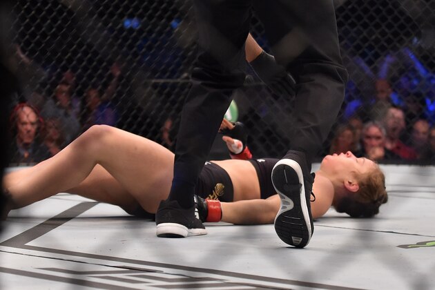Ronda Rousey of the US hits the canvas after being knocked out by compatriot Holly Holm by a kick to the neck to end the UFC title fight in Melbourne on November 15, 2015.   RESTRICTED TO EDITORIAL USE NO ADVERTISING USE NO PROMOTIONAL USE NO MERCHANDISING USE.  AFP PHOTO/Paul CROCK        (Photo credit should read PAUL CROCK/AFP/Getty Images)