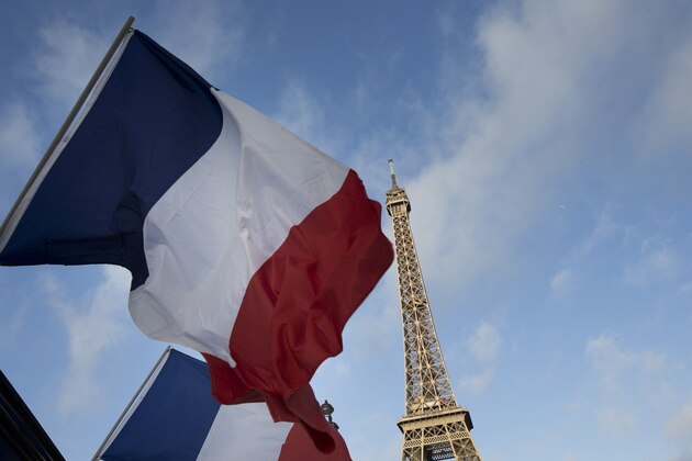 French flags fly as the closed Eiffel Tower is seen in the background on the first of three days of national mourning in Paris, Sunday, Nov. 15, 2015. The Islamic State group claimed responsibility for Friday's attacks on a stadium, a concert hall and Paris cafes that left 129 people dead and over 350 wounded, 99 of them seriously. (AP Photo/Peter Dejong)