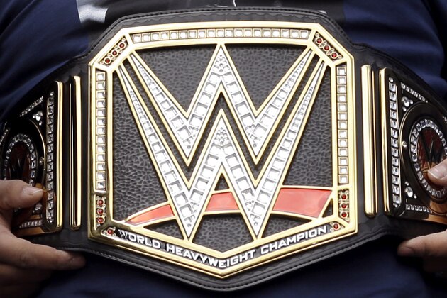 New England Patriots defensive lineman Alan Branch, center, wears a WWE belt during a victory parade in Boston Wednesday, Feb. 4, 2015, held to honor the team after defeating the Seattle Seahawks 28-24 in Super Bowl XLIX Sunday, in Glendale, Ariz. (AP Photo/Steven Senne)