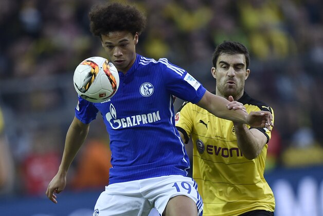 Schalke's Leroy Sane, left, and Dortmund's Sokratis challenge for the ball during the German Bundesliga soccer match between Borussia Dortmund and FC Schalke 04 in Dortmund, Germany, Sunday, Nov. 8, 2015. (AP Photo/Martin Meissner)