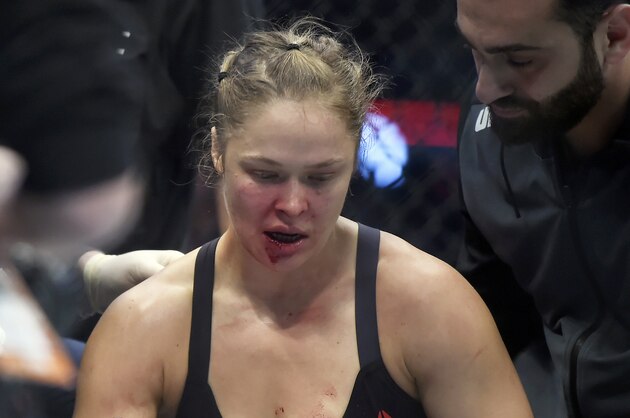Ronda Rousey is treated by a medical staff member after being knocked out by Holly Holm in their UFC 193 bantamweight title fight in Melbourne, Australia, Sunday, Nov. 15, 2015. Holm pulled off a stunning upset victory over Rousey in the fight, knocking out the women's bantamweight champion in the second round with a powerful kick to the head Sunday.  (AP Photo/Andy Brownbill)