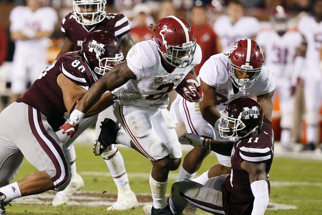 Alabama running back Derrick Henry (2) fights offs an attempted tackles by Mississippi State defensive back Kivon Coman (11) and defensive lineman Nick James (88) on his way to a short gain during the second half of an NCAA college football game in Starkville, Miss., Saturday, Nov. 14, 2015. No. 3 Alabama won 31-6. (AP Photo/Rogelio V. Solis)