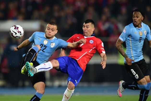 Uruguayan Jonathan Rodriguez (L) vies for the ball with Chilean Gary Medel (C) during the Copa America football match in Santiago on June 24, 2015. AFP PHOTO / MARTIN BERNETTI        (Photo credit should read MARTIN BERNETTI/AFP/Getty Images)