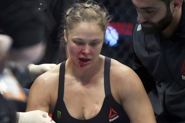Ronda Rousey is treated by a medical staff member after being knocked out by Holly Holm in their UFC 193 bantamweight title fight in Melbourne, Australia, Sunday, Nov. 15, 2015. Holm pulled off a stunning upset victory over Rousey in the fight, knocking out the women's bantamweight champion in the second round with a powerful kick to the head Sunday.  (AP Photo/Andy Brownbill)