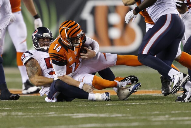 Cincinnati Bengals quarterback Andy Dalton (14) is sacked by Houston Texans outside linebacker John Simon (51) in the second half of an NFL football game in Cincinnati, Monday, Nov. 16, 2015.  (AP Photo/Gary Landers)