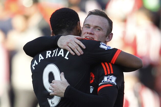 Manchester United's English striker Wayne Rooney embraces Manchester United's French striker Anthony Martial (L) after the English Premier League football match between Southampton and Manchester United at St Mary's Stadium in Southampton, southern England on September 20, 2015. Manchester United won the game 3-2. AFP PHOTO / IAN KINGTON

RESTRICTED TO EDITORIAL USE. No use with unauthorized audio, video, data, fixture lists, club/league logos or 'live' services. Online in-match use limited to 75 images, no video emulation. No use in betting, games or single club/league/player publications.        (Photo credit should read IAN KINGTON/AFP/Getty Images)
