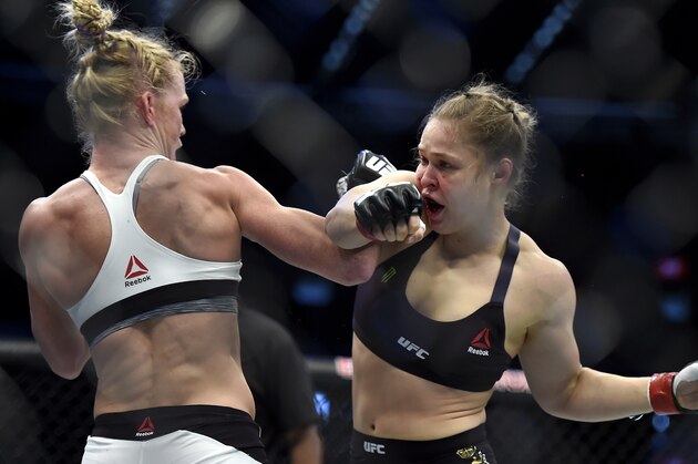Holly Holm, left, and Ronda Rousey exchange their punches during their UFC 193 bantamweight title fight in Melbourne, Australia, Sunday, Nov. 15, 2015. Holm pulled off a stunning upset victory over Rousey in the fight, knocking out the women's bantamweight champion in the second round with a powerful kick to the head Sunday. (AP Photo/Andy Brownbill)