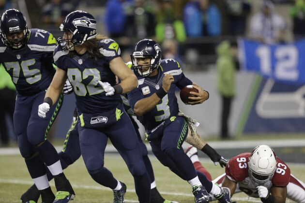 As Seattle Seahawks' Russell Okung (76) and Luke Willson (83) block, quarterback Russell Wilson (3) rushes against the Arizona Cardinals in the first half of an NFL football game, Sunday, Nov. 15, 2015, in Seattle. (AP Photo/Stephen Brashear)