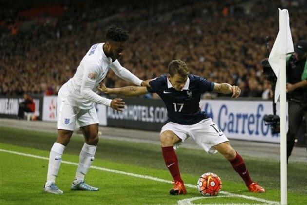 France's Lucas Digne fights for the ball against England’s Raheem Sterling during the international friendly soccer match between England and France at Wembley Stadium in London, Tuesday, Nov. 17, 2015. France is playing England at Wembley on Tuesday after the countries decided the match should go ahead despite the deadly attacks in Paris last Friday night which killed scores of people. (AP Photo/Kirsty Wigglesworth)