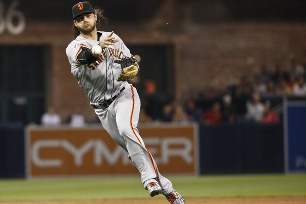 San Francisco Giants shortstop Brandon Crawford makes the running throw across his body to get San Diego Padres' Jedd Gyorko at first base in the third inning of a baseball game Monday, July 20, 2015, in San Diego.   (AP Photo/Lenny Ignelzi)