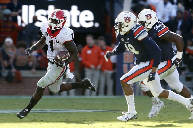 Georgia running back Sony Michel (1) carries the ball around Auburn defensive back Carlton Davis (18) and linebacker Tre' Williams (30) during the second half of an NCAA football game, Saturday, Nov. 14, 2015, in Auburn, Ala. Georgia won 20-13. (AP Photo/Butch Dill)