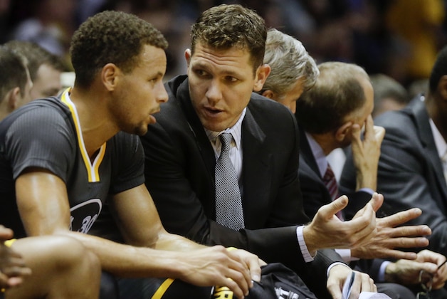 Golden State Warriors interim coach Luke Walton talks with guard Stephen Curry in the first half of an NBA preseason basketball game Saturday, Oct. 17, 2015, in San Diego.  (AP Photo/Lenny Ignelzi)