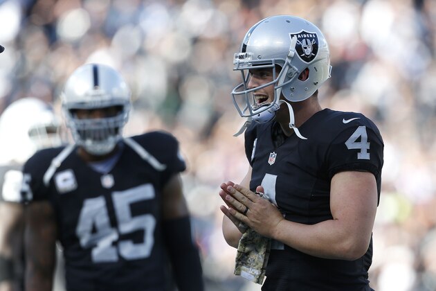 Oakland Raiders quarterback Derek Carr (4) celebrates after throwing a touchdown to wide receiver Andre Holmes during the first half of an NFL football game against the Minnesota Vikings in Oakland, Calif., Sunday, Nov. 15, 2015. (AP Photo/Beck Diefenbach)