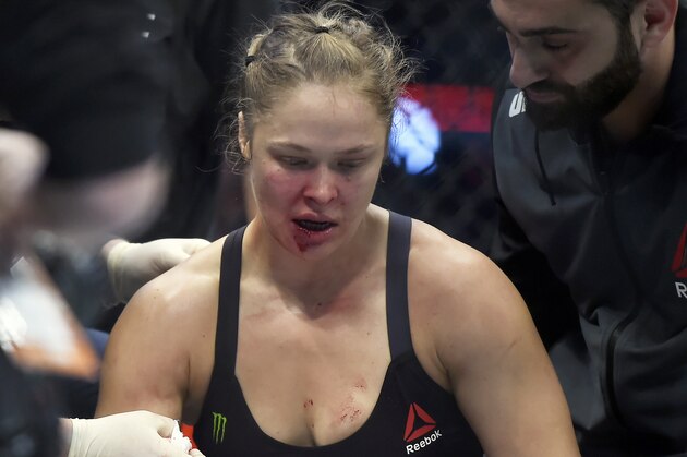 Ronda Rousey is treated by a medical staff member after being knocked out by Holly Holm in their UFC 193 bantamweight title fight in Melbourne, Australia, Sunday, Nov. 15, 2015. Holm pulled off a stunning upset victory over Rousey in the fight, knocking out the women's bantamweight champion in the second round with a powerful kick to the head Sunday.  (AP Photo/Andy Brownbill)