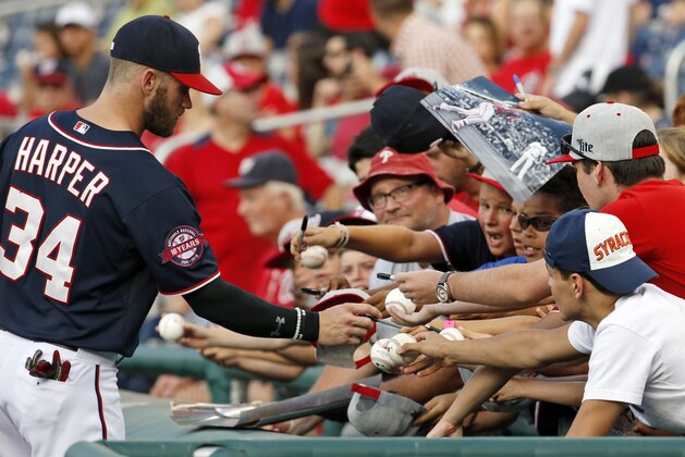Washington Nationals right fielder Bryce Harper (34) prepares to sign autographs for fans before a baseball game against the Milwaukee Brewers at Nationals Park, Friday, Aug. 21, 2015, in Washington. (AP Photo/Alex Brandon)