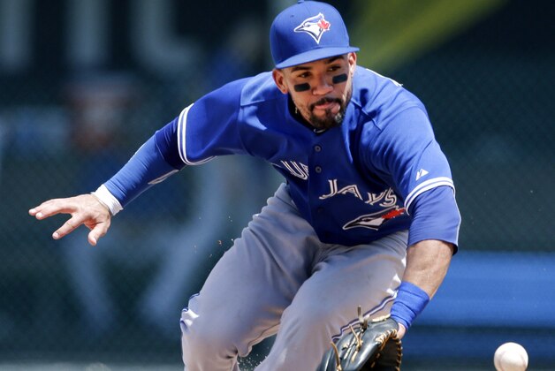 Toronto Blue Jays second baseman Devon Travis fields a ball hit by Kansas City Royals' Mike Moustakas during the sixth inning of a baseball game at Kauffman Stadium in Kansas City, Mo., Saturday, July 11, 2015. Moustakas was out at first base on the play. (AP Photo/Orlin Wagner)