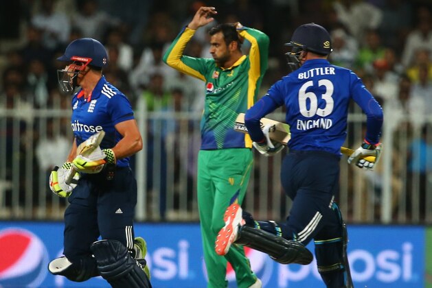 England's Jos Buttler (R) and James Taylor (L) run between the wickets as Pakistan's Sohaib Mailk reacts during the third One Day International (ODI) match between Pakistan and England at the Sharjah Cricket Stadium in the Gulf Emirate of Sharjah on November 17, 2015. AFP PHOTO / MARWAN NAAMANI        (Photo credit should read MARWAN NAAMANI/AFP/Getty Images)