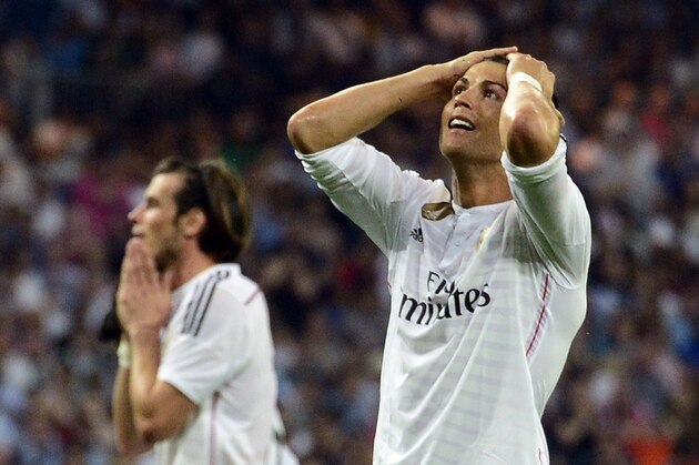 Real Madrid's Portuguese forward Cristiano Ronaldo (R) reacts after missing a kick next to Real Madrid's Welsh forward Gareth Bale during the Spanish league football match Real Madrid CF vs Valencia CF at the Santiago Bernabeu stadium in Madrid on May 9, 2015.   AFP PHOTO/ GERARD JULIEN        (Photo credit should read GERARD JULIEN/AFP/Getty Images)