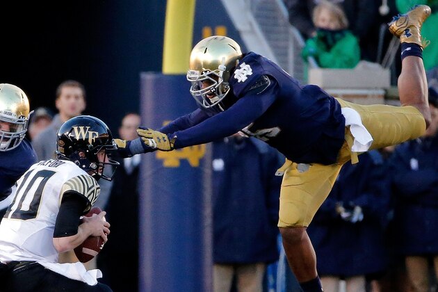 SOUTH BEND, IN - NOVEMBER 14:  Romeo Okwara #45 of the Notre Dame Fighting Irish leaps through the air to sack John Wolford #10 of the Wake Forest Demon Deacons during the second quarter at Notre Dame Stadium on November 14, 2015 in South Bend, Indiana.  (Photo by Jon Durr/Getty Images)