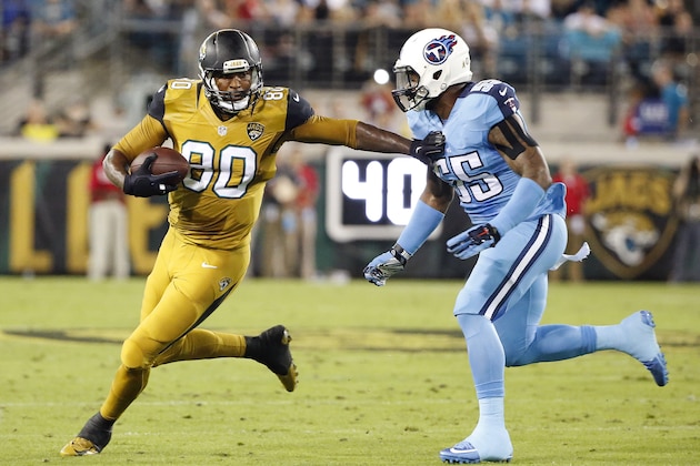 Jacksonville Jaguars tight end Julius Thomas (80) stiff arms Tennessee Titans inside linebacker Zach Brown (55) during the first quarter of an NFL football game Thursday, Nov. 19, 2015, in Jacksonville, Fla. (AP Photo/Brian Blanco)