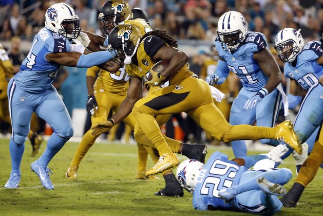 Jacksonville Jaguars running back Denard Robinson (16) is tripped by Tennessee Titans cornerback Perrish Cox (29) during the second quarter of an NFL football game Thursday, Nov. 19, 2015, in Jacksonville, Fla. (AP Photo/Brian Blanco)