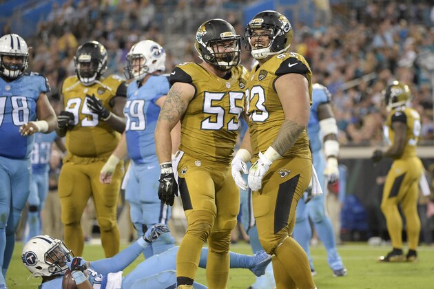 Jacksonville Jaguars outside linebacker Dan Skuta (55) and defensive tackle Tyson Alualu (93) celebrate after stopping Tennessee Titans running back David Cobb, bottom, during the first half of an NFL football game in Jacksonville, Fla., Thursday, Nov. 19, 2015.(AP Photo/Phelan M. Ebenhack)