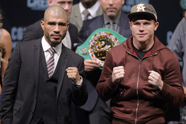 Former WBC Middleweight World Champion Miguel Cotto (L), from Puerto Rico and two time world champion, Saul 'Canelo' Alvarez from Guadalajara, Mexico pose during a press conference in Las Vegas, Nevada on November 18, 2015.  Cotto was stripped of his World Boxing Council middleweight world title on Tuesday, days before his anticipated bout against Mexican Saul Alvarez in Las Vegas on Saturday. Amid reports that Cotto declined to pay the USD 300,000 sanctioning fee for a title fight, the WBC said in a statement only that the Puerto Rican and his camp failed to comply with WBC regulations. AFP PHOTO/ John Gurzinski        (Photo credit should read JOHN GURZINSKI/AFP/Getty Images)