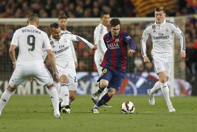 Real Madrid's Karim Benzema, left, Real Madrid's Raphel Varane, second left, Real Madrid's Toni Kroos, right, Real Madrid's Cristiano Ronaldo, rear center, and Real Madrid's goalkeeper Iker Casillas, left, watch as Barcelona's Lionel Messi, center, drybbles with the ball during a Spanish La Liga soccer match between FC Barcelona and Real Madrid at Camp Nou stadium, in Barcelona, Spain, Sunday, March 22, 2015. (AP Photo/Emilio Morenatti)