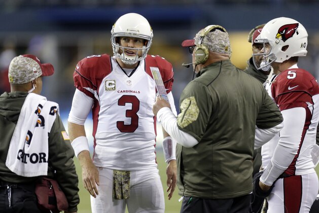 Arizona Cardinals quarterback Carson Palmer (3) talks with head coach Bruce Arians, second from right, during the first half of an NFL football game against the Seattle Seahawks, Sunday, Nov. 15, 2015, in Seattle. (AP Photo/Stephen Brashear)