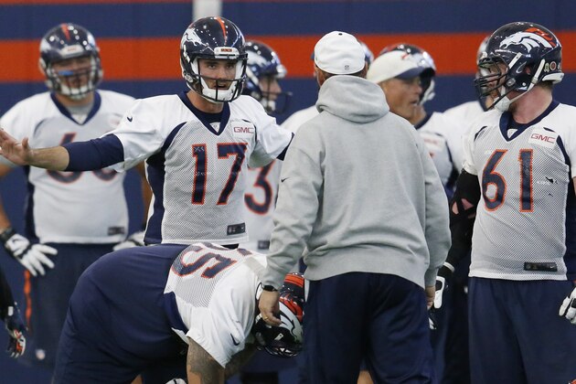 Denver Broncos quarterback Brock Osweiler, back, talks to offensive coordinator Rick Dennison, front, during a practice session at the team's headquarters Wednesday, Nov. 18, 2015, in Englewood, Colo. (AP Photo/David Zalubowski)