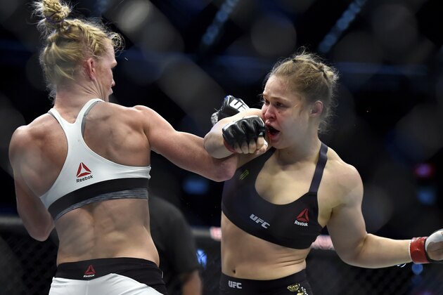 Holly Holm, left, and Ronda Rousey exchange their punches during their UFC 193 bantamweight title fight in Melbourne, Australia, Sunday, Nov. 15, 2015. Holm pulled off a stunning upset victory over Rousey in the fight, knocking out the women's bantamweight champion in the second round with a powerful kick to the head Sunday. (AP Photo/Andy Brownbill)